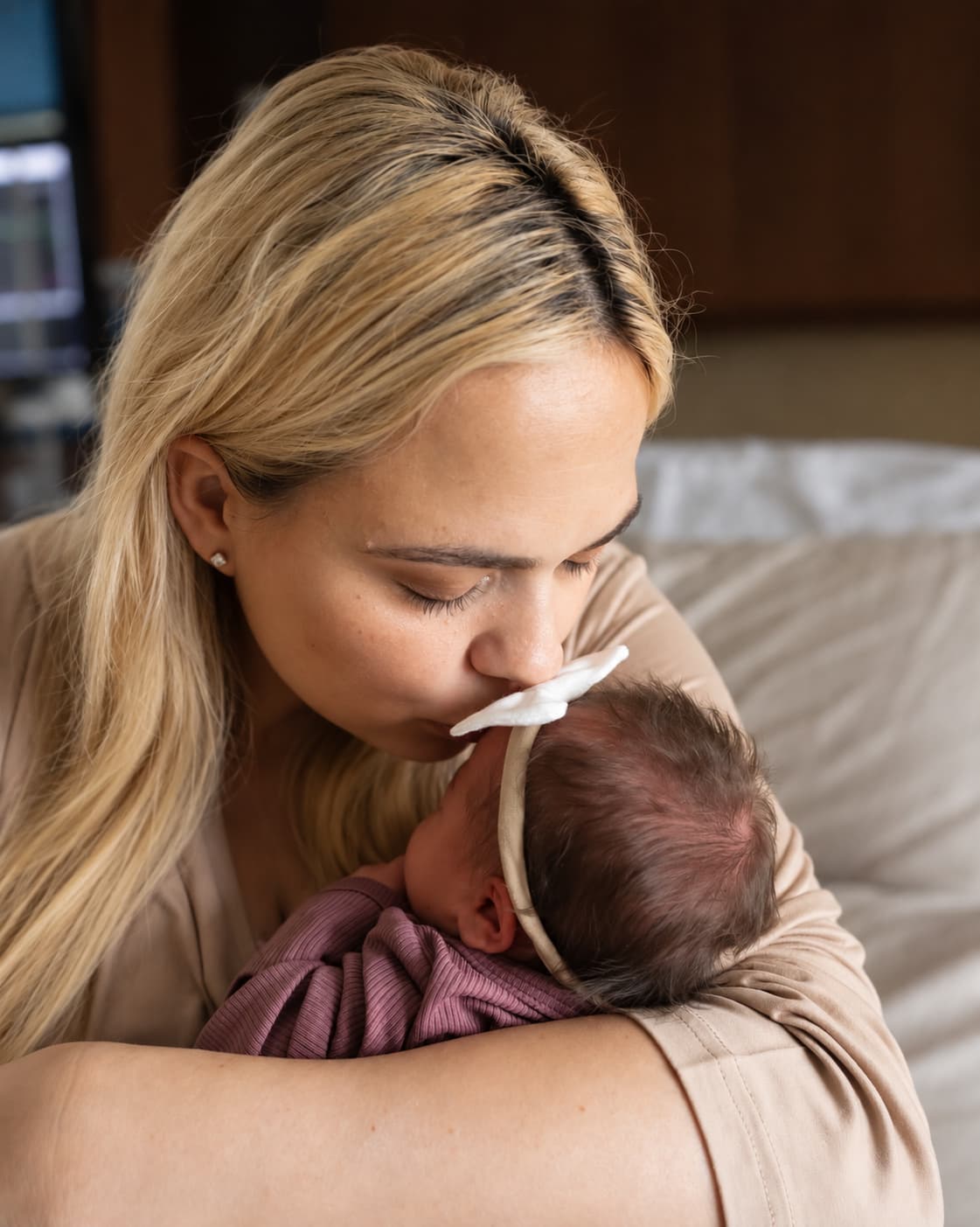 Amanda holding our daughter close and kissing the top of her head.